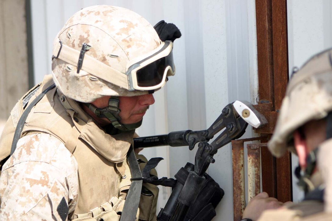 CAMP FALLUJAH, IRAQ – Marines from Company I, 3rd Battalion, 8th Marine Regiment, Regimental Combat Team 8, cut the locks on local warehouses as they searched over a total of 100 buildings.  The manager of the facility helped out greatly unlocking what he could, while others were cut to ensure no insurgent activity or weapons caches were inside.  Official U.S. Marine Corps photo by Lance Cpl. Athanasios L. Genos