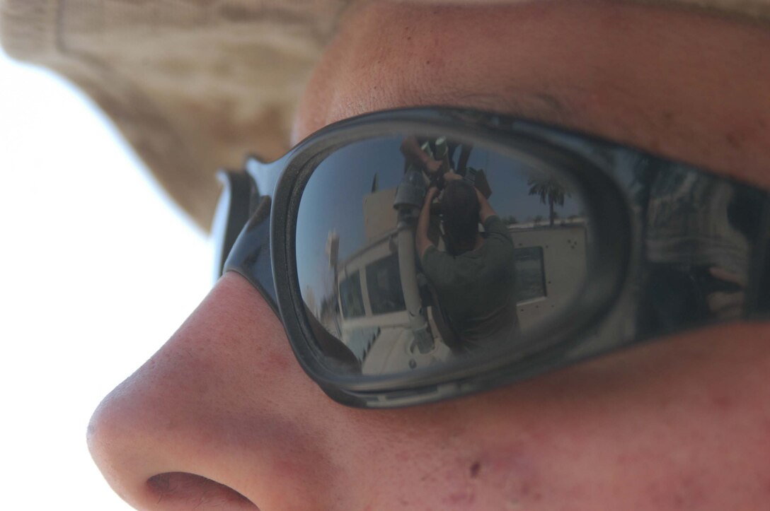 CAMP HURRICANE POINT, Ar Ramamdi, Iraq (March 31, 2005) -Twenty-one-year-old Lance Cpl. John S. Summers Jr., of Indianapolis, an anti tank assault man and driver for Whiskey 5, Weapons Company, 1st Battalion, 5th Marines, watches Cpl. Michalson Bahe and Pfc. David S. Johnson, motor transportation mechanics with Headquarters and Service Company, 1st Battalion, 5th Marines, fix his humvee at the garage here. Bahe and Johnson boast a 24-hour turn around time on all the vehicles they work on. The two grease monkeys are responsible for maintaining and repairing 90 of the infantry battalion's vehicles. They stay on call during the night and routinely find themselves burning the midnight oil fixing humvees and 7-tons at their shop. Photo by Cpl. Tom Sloan