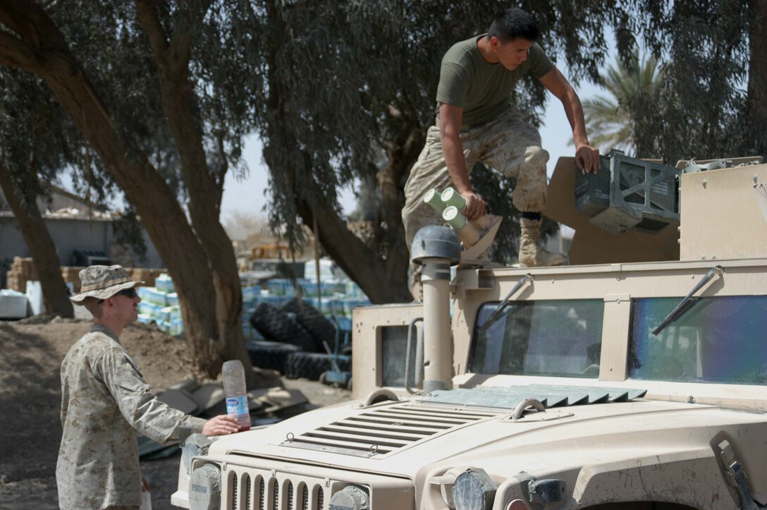 CAMP HURRICANE POINT, Ar Ramamdi, Iraq (March 31, 2005) -Twenty-one-year-old Lance Cpl. John S. Summers Jr., of Indianapolis, an anti tank assault man and driver for Whiskey 5, Weapons Company, 1st Battalion, 5th Marines, watches 21-year-old Cpl. Michalson Bahe of Casa Grande, Ariz., a motor transportation mechanic with Headquarters and Service Company, 1st Battalion, 5th Marines, fix his humvee at the garage here. Bahe and Pfc. David S. Johnson, who's also a motor T mechanic, boast a 24-hour turn around time on all the vehicles they work on. The two grease monkeys are responsible for maintaining and repairing 90 of the infantry battalion's vehicles. They stay on call during the night and routinely find themselves burning the midnight oil fixing humvees and 7-tons at their shop. Photo by Cpl. Tom Sloan