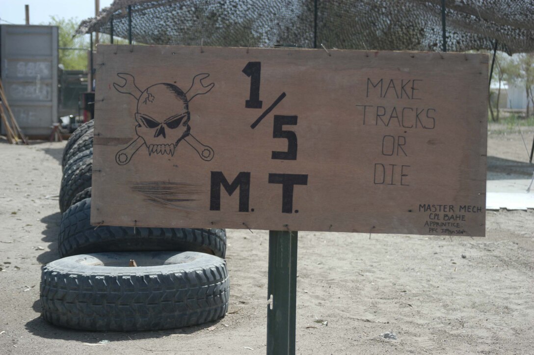CAMP HURRICANE POINT, Ar Ramamdi, Iraq (March 31, 2005) - A sign greets drivers who bring their vehicles to the garage here. Corporal Michalson Bahe and Pfc. David S. Johnson, motor transportation mechanics with Headquarters and Service Company, 1st Battalion, 5th Marines, boast a 24-hour turnover period on all the vehicles they work on The two grease monkeys are responsible for maintaining and repairing 90 of the infantry battalion's vehicles. They stay on call during the night and routinely find themselves burning the midnight oil fixing humvees and 7-tons at their shop. Photo by Cpl. Tom Sloan