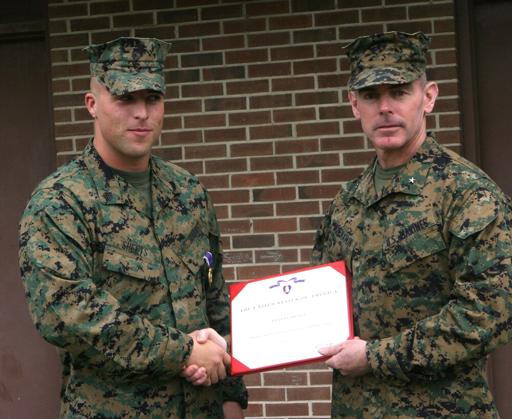 MARINE CORPS BASE CAMP LEJEUNE, N.C. - Sergeant Brent Sheets, motor transport chief for Company B, 2nd Tank Battalion, 2nd Marine Division, left, is presented his Purple Heart Medal here Oct. 31.  The 22-year-old Salisbury, N.C. native and fellow Marine, Lance Cpl. Brandon Wells, were both awarded this medal for injuries sustained after a roadside bomb detonated near their vehicle while they had been conducting security and stability operations in Iraq's Al Anbar province May 1.