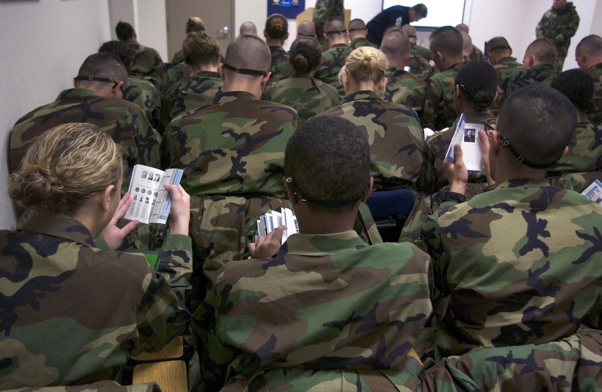 LACKLAND AIR FORCE BASE, Texas -- Air Force trainees review their new Airman handbooks after Chief Master Sgt. of the Air Force Gerald R. Murray presented them to the Airmen of the 326th Training Squadron here.  The handbook is a pocket-sized book that covers heritage, national leaders, Air Force operations and a variety of military-related topics.  A copy is being provided to every new Airman.  (U.S. Air Force photo by Master Sgt. Efrain Gonzalez)