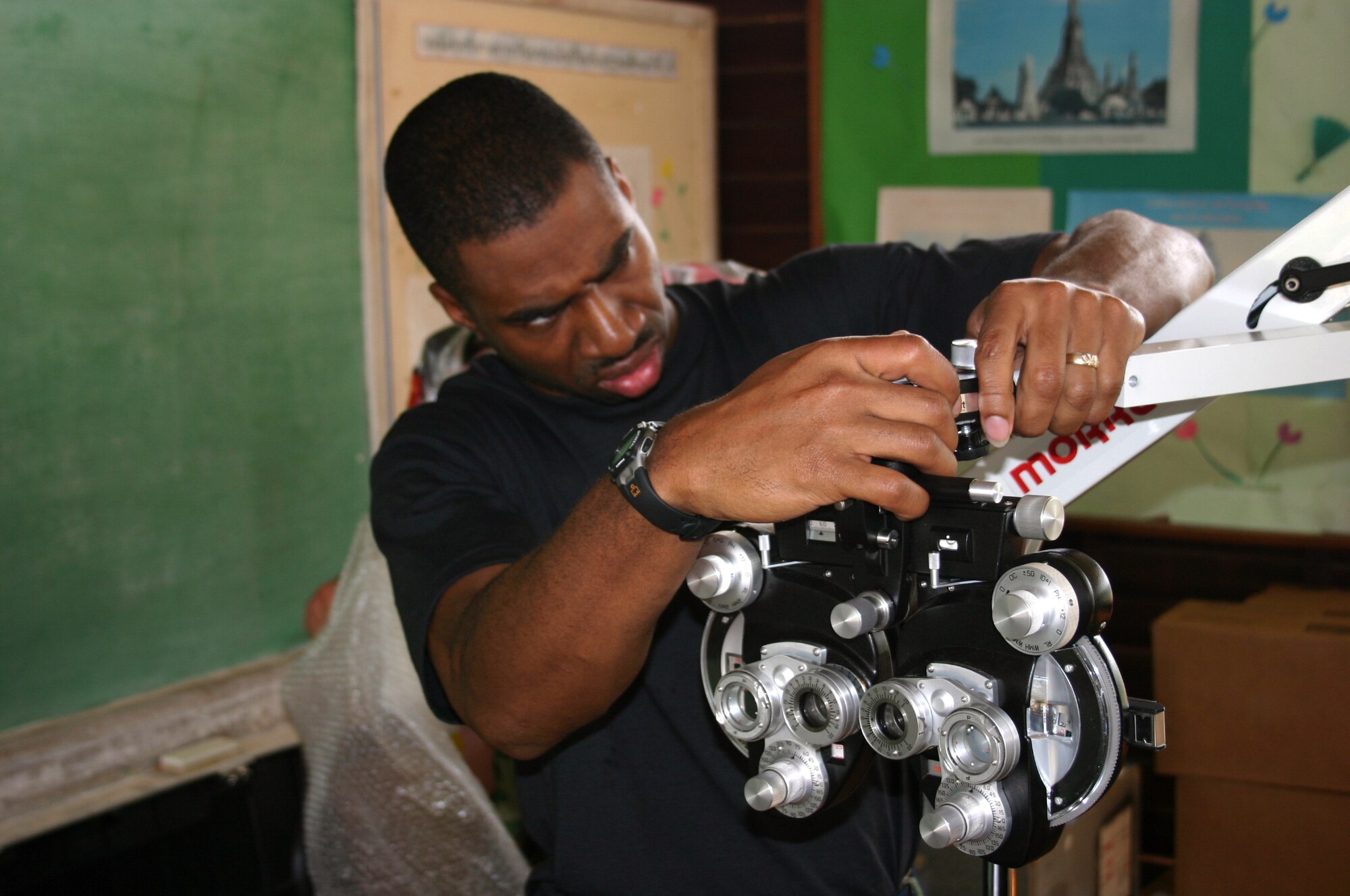 KORAT, Thailand -- Staff Sgt. Fred McCree sets up optical equipment at a school here Jan 28.  Military medical teams from the Air Force, Navy, Thailand and Singapore are easing suffering by giving ocular and dental care to local people.  Sergeant McCree is an optometry craftsman from the 18th Medical Group at Kadena Air Base, Japan. (U.S. Air Force photo by 2nd. Lt. Ben Sakrisson)
