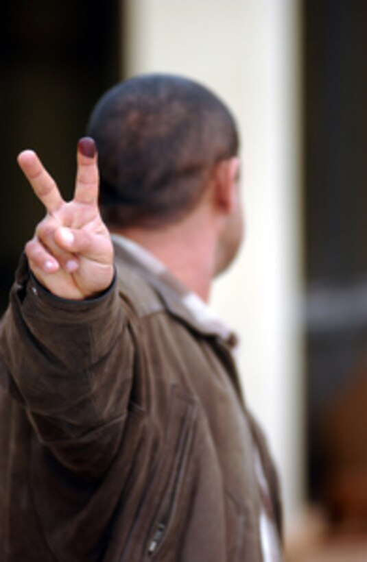 An Iraqi citizen, turning his head to protect his identity, proudly displays the indelible ink on his finger as proof he has voted in Iraq's first free election in over 50 years on Jan. 30, 2005. Everyone voting in the historic election has to mark their finger with the ink to indicate they have already voted as a means to deter voting fraud. 