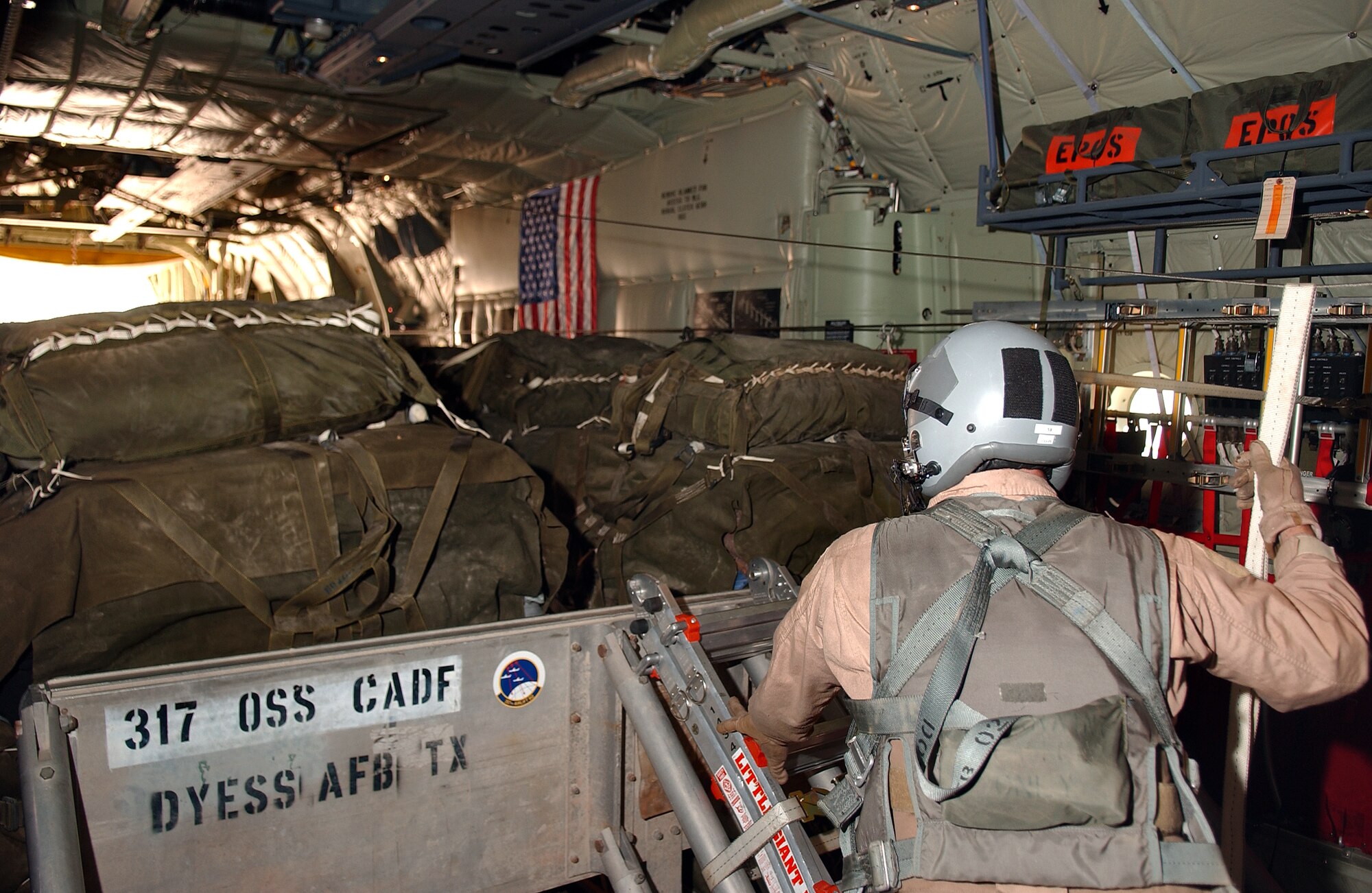 SOUTHWEST ASIA -- Master Sgt. Sean Ballard watches as a container delivery system bundle rolls out of the back of a C-130J Hercules June 30.  This mission was the first-ever combat airdrop for the new J-model transport.  Sergeant Ballard is a loadmaster with the Rhode Island Air National Guard's 143rd Air Wing.  (U.S. Air Force photo by Airman 1st Class Desiree Hayden)