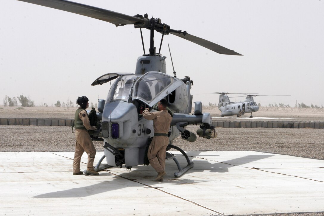 AL ASAD, Iraq ? Cpl. Travis L. Borkowski, mechanic and electrician with the Ground Support Equipment division of Marine Aviation Logistics Squadron 26, removes the drain plug from a wench drum while changing the oil on a maintenance crane July 1.  Borkowski, from Manning, Iowa, is one of the Marines who assist behind the scenes with the maintenance of the aircraft of the 2nd Marine Aircraft Wing (Forward).