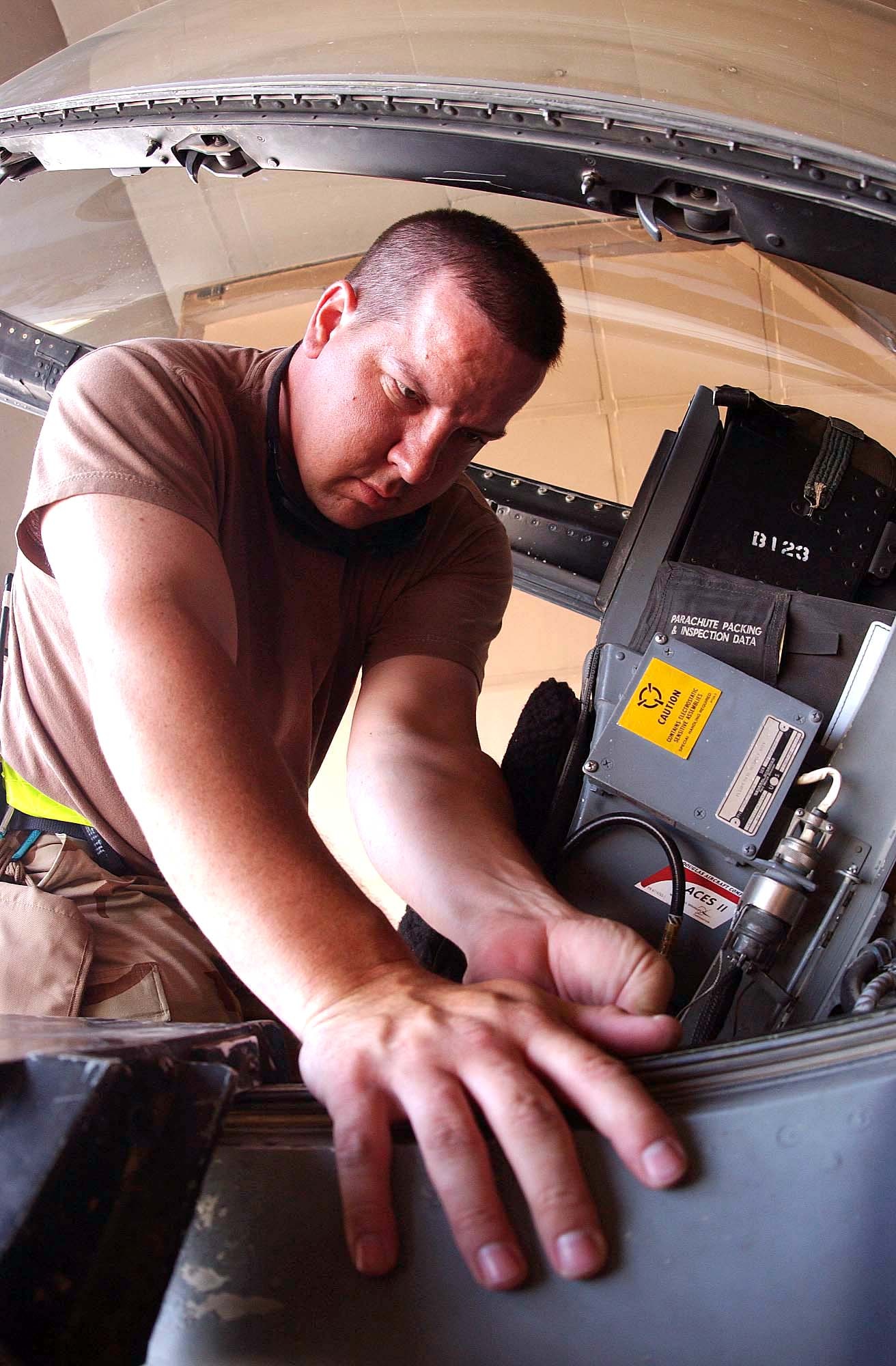 BALAD AIR BASE, Iraq -- Tech. Sgt. Brad Smith conducts a final inspection on hook lever bolts along the sides of an F-16 Fighting Falcon cockpit.  If a pilot must eject, the bolts break off, releasing the canopy.  Sergeant Smith is the 510th Aircraft Maintenance Unit's aircrew egress supervisor here.  (U.S. Air Force photo by Senior Airman Tim Beckham)
             