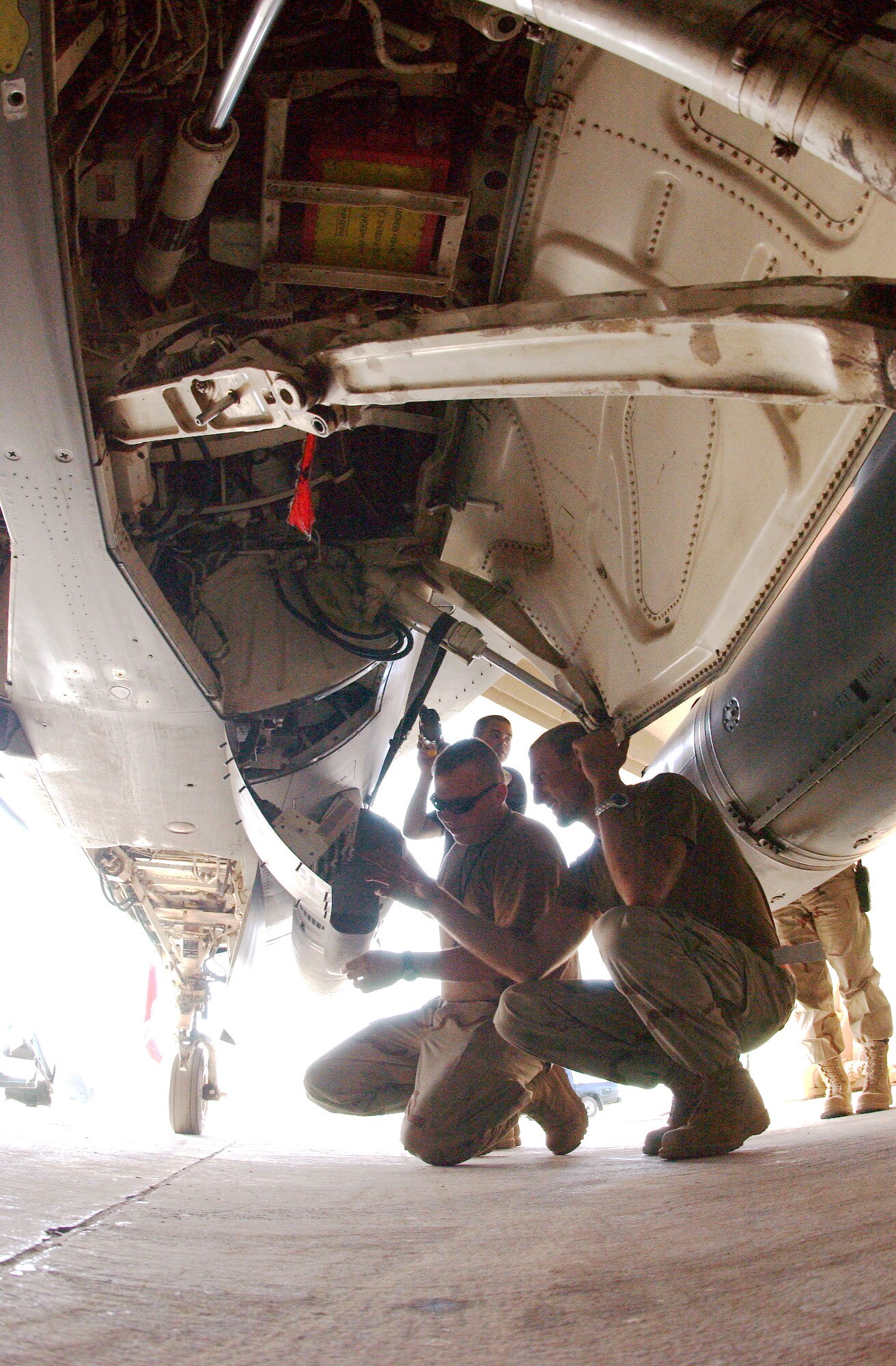BALAD AIR BASE, Iraq -- Staff Sgt. James Lucas and Senior Airman Justin Foulsham install a liquid oxygen converter on an F-16 Fighting Falcon here.  They are aircraft maintainers with the 332nd Expeditionary Aircraft Maintenance Squadron.  (U.S. Air Force photo by Senior Airman Tim Beckham)                               