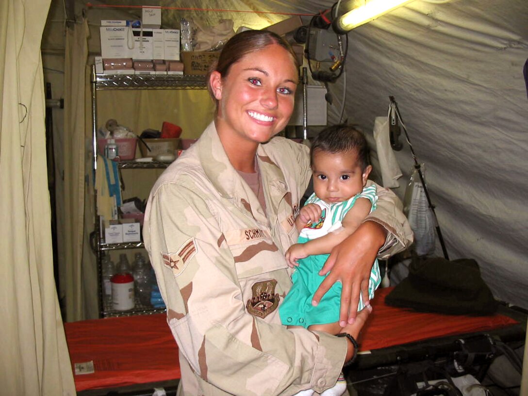 KIRKUK AIR BASE, Iraq -- Airman 1st Class Nicole Schmitt holds a 3-month-old local boy after medics with the 506th Expeditionary Medical Squadron here successfully performed surgery to save the baby's life. (U.S. Air Force photo)