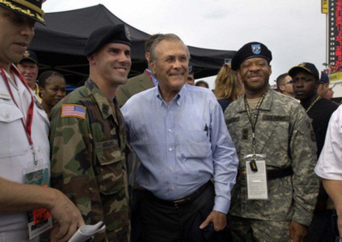 Secretary of Defense Donald H. Rumsfeld poses for photographs with Army Recruiter Master Sgt. Michael Wiggins (left) and Army Maj. Gen. Larry Knightner (right) before the start of the Pepsi 400 at Daytona International Speedway, Fla., on July 2, 2005. Rumsfeld met with NASCAR fans, drivers and their pit crews as he toured the infield before the race. Rumsfeld served as the as the Grand Marshal of the 47th running of the Pepsi 400 and gave the command "Gentlemen, start your engines". 
