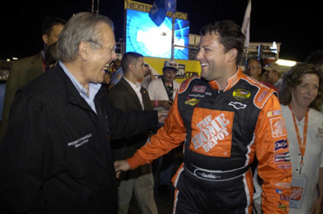 Secretary of Defense Donald H. Rumsfeld shares a laugh with Tony Stewart, driver of the number 20 Home Depot Chevrolet, before the start of the Pepsi 400 at the Daytona International Speedway, Fla., July 2, 2005. Rumsfeld served as the as the Grand Marshal of the 47th running of the Pepsi 400 and met with NASCAR fans, drivers and their pit crews as he toured the infield before the race. Stewart earned the pole position for the race. 