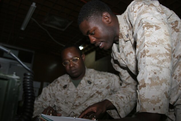 AL ASAD, Iraq ? Corporal Allen Jones, the air tasking order production chief with Marine Wing Headquarters Squadron 2 discusses a problem with Master Sgt. Curtis Clark, the future operations chief with the forward deployed 2nd Marine Aircraft Wing. Jones is stationed at Marine Corps Air Station, Beaufort, S. C.