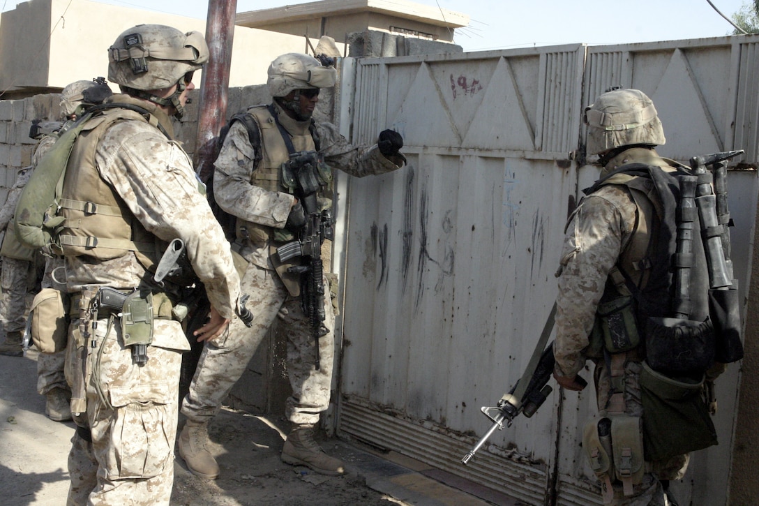 FALLUJAH, Iraq - Marines with Company B, 1st Battalion, 6th Marine Regiment prepare to enter a household here July 7.  Company B personnel conducted Operation Hard Knock alongside Iraqi Security Forces here, during which the troops wired off entire neighborhoods and searched through each house for concealed weapons and explosives.