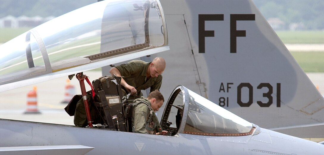 LANGLEY AIR FORCE BASE, Va. -- Airman 1st Class Caleb Saunders and Maj. John Braun make adjustments to an F-15 Eagle cockpit seat in preparation to fly a combat air patrol mission from here July 1.  Pilots patrolled the sky over the Washington, D.C., area providing presidential support during the Fourth of July weekend.  Major Braun is an F-15 pilot with the 94th Fighter Squadron, and Airman Saunders is assigned to the 94th Aircraft Maintenance Squadron.  (U.S. Air Force photo by Staff Sgt. Eric Sheler)