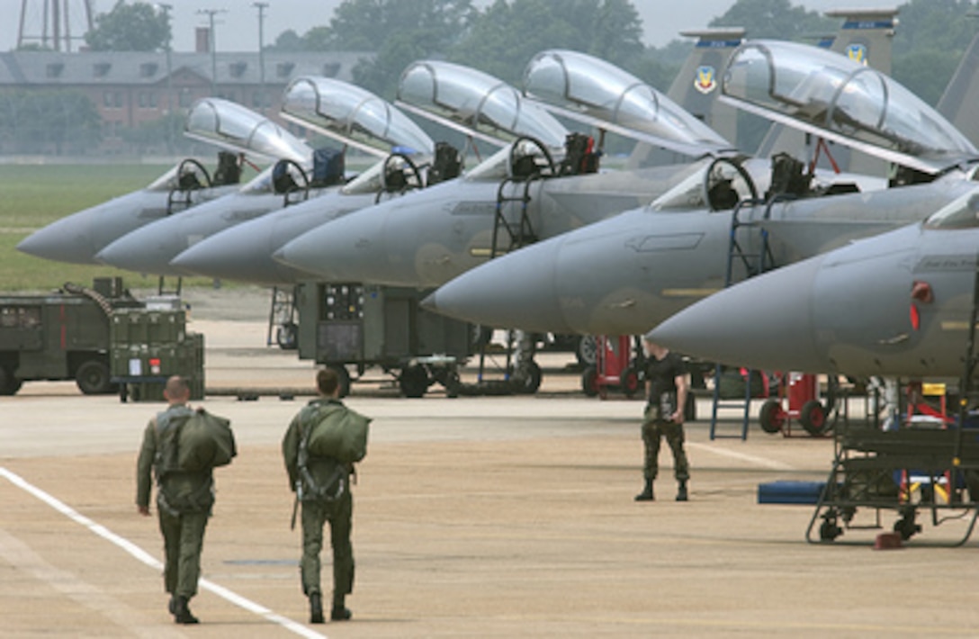 Air Force Capt. Matt Johnson (left) and Tech. Sgt. Ben Bloker (right) walk the flight line to a F-15 Eagle at Langley Air Force Base, Va., on July 1, 2005. Johnson and Bloker will conduct an aerial photography mission in support of Operation Noble Eagle. 