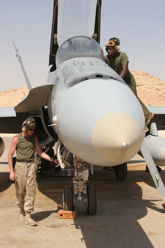 AL ASAD, Iraq ? Corporal Anthony Harper, a native of Lithia Springs, Ga., and Cpl. Sherwin Starks, a native of Winder, Ga., both F/A-18 Hornet mechanics with Marine Fighter Attack Squadron 142, perform a post-flight inspection minutes after the aircraft was parked on the Gator flightline here. The powerline division works two shifts, working 12-hours each, everyday.