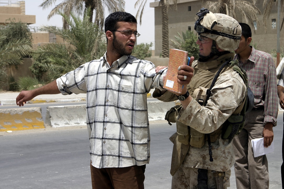 FALLUJAH, Iraq - Lance Cpl. Caleb Clugston, an infantryman with 2nd Platoon, Company B, 1st Battalion, 6th Marine Regiment, frisks a citizen here July 7 to look for weapons and ammunition.  Company B personnel conducted Operation Hard Knock alongside Iraqi Security Forces here, during which the troops wired off entire neighborhoods and searched through each house for concealed weapons and explosives.