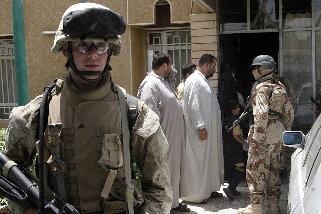 FALLUJAH, Iraq - Lance Cpl. Raleigh Krigbaum, an infantryman with 2nd Platoon, Company B, 1st Battalion, 6th Marine Regiment, provides security outside a home here July 7 during Operation Hard Knock.  The 19-year-old Canton, Ohio native helped fellow infantrymen conduct this mission alongside Security Forces here, during which the troops wired off entire neighborhoods and searched through each house for concealed weapons and explosives.