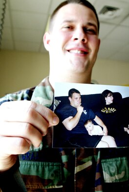 POPE AIR FORCE BASE, N.C. -- Senior Airman Brian Graack shows off a picture of himself a short time before he got the ultimatum to lose weight and get in shape or get out of the Air Force.  Since training for his sixth and finally successful fitness test, Airman Graack scored a good rating, as opposed to past poor ratings.  He is assigned to the 43rd Aircraft Maintenance Squadron.  (U.S. Air Force photo by Senior Airman Stacia Zachary)