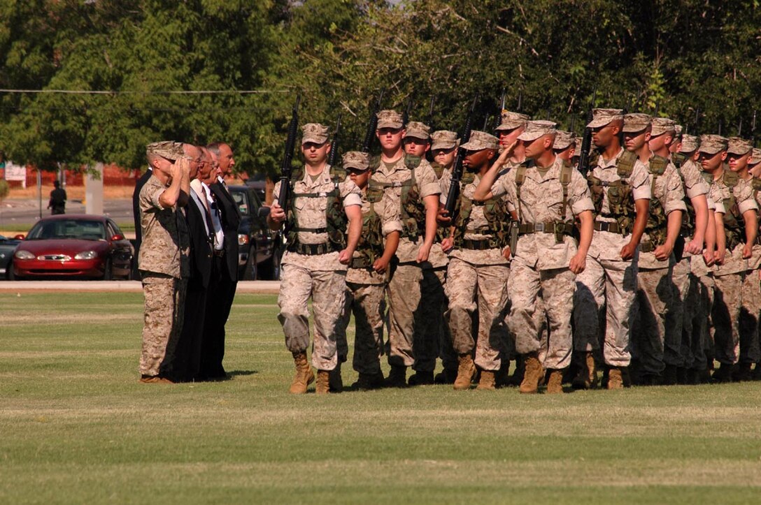 Standing left, Col. Ben D. Hancock, station incoming commanding officer, Col. James J. Cooney, station outgoing commanding officer, and former station COs observe the parade in the station change of command ceremony as it passes in review June 7.