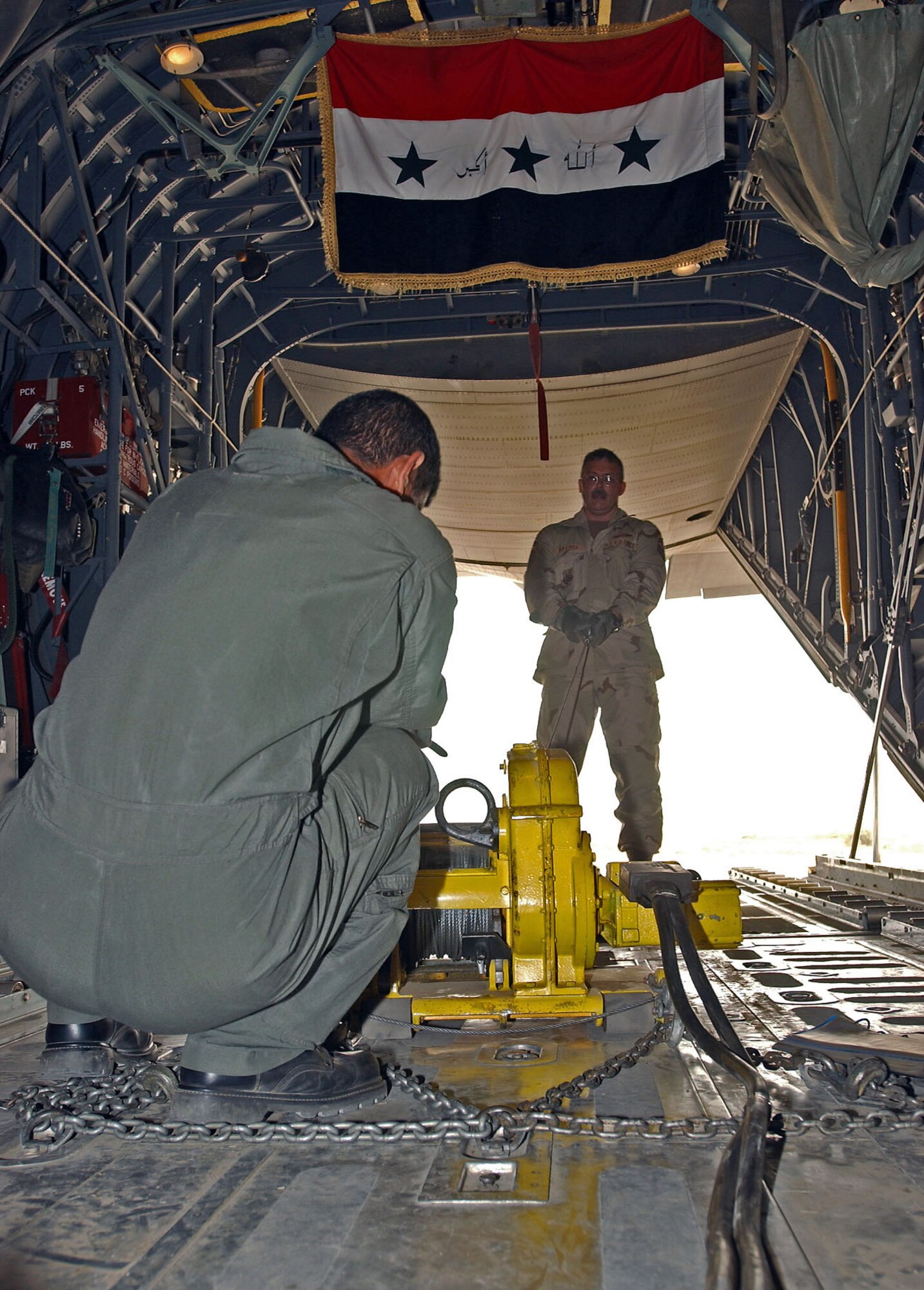 ALI BASE, Iraq -- Senior Master Sgt. James Baarda teaches an Iraqi air force student to operate a bulldog winch used to load rolling stock cargo and equipment.  He is part of a crew of more than 30 instructors teaching more than 100 Iraqi airmen how to fly and maintain C-130s here.  Sergeant Baarda is a loadmaster instructor assigned to the 777th Expeditionary Airlift Squadron and is deployed from Yokota Air Base, Japan.  (U.S. Air Force photo by Airman 1st Class Jamie Shultz)