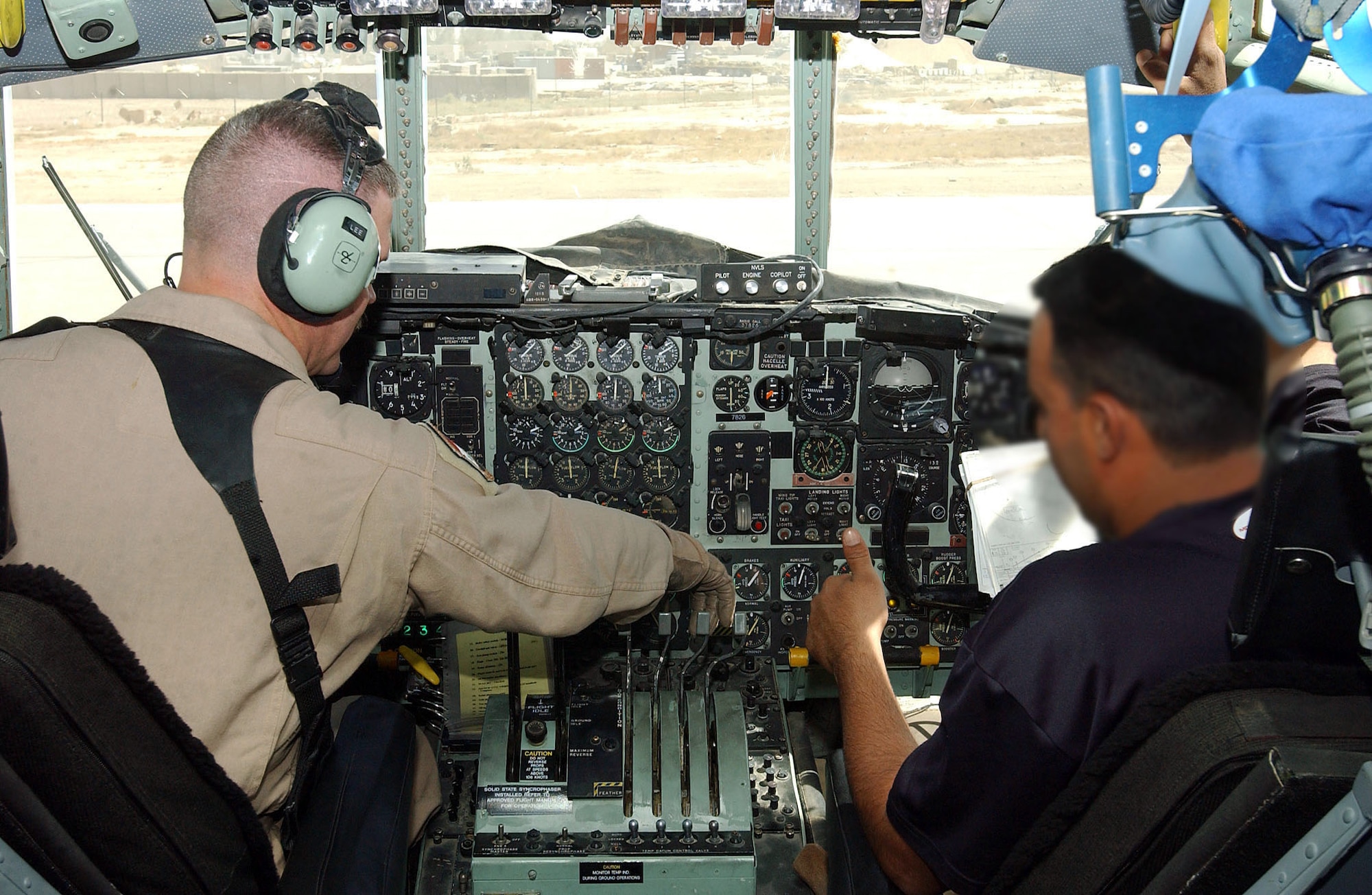 ALI BASE, Iraq -- Master Sgt. Tommy Lee reviews the instruments on a C-130 Hercules control panel with one of his Iraqi air force students.  He is among more than 30 instructors teaching more than 100 Iraqi airmen how to fly and maintain C-130s here.  Sergeant Lee is a flight engineer instructor assigned to the 777th Expeditionary Airlift Squadron and is deployed from Little Rock Air Force Base, Ark.  The student's face is blurred for his protection.  (Altered U.S. Air Force photo by Airman 1st Class Jamie Shultz)