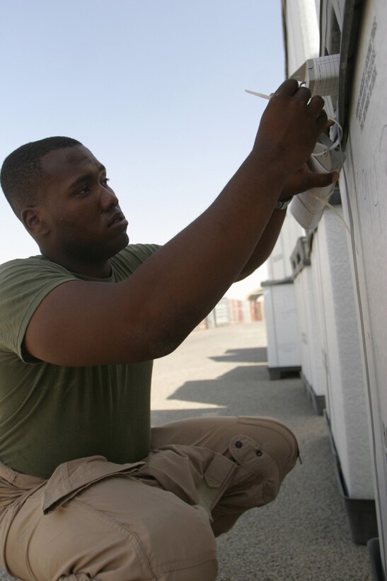 CAMP TAQADDUM, Iraq -- Corporal Thomas A. Douglas, a Columbus, Ohio, native and warehouse chief for the Initial Issues Provision, places a Radio Frequency Identification tag on a tri-wall before it is sent to the unit who ordered the gear.  The IIP is part of the Supply Management Unit of Combat Logistics Regiment 25, 2d Force Service Support Group (Forward).  The SMU has a 94 percent requisition fill rate.