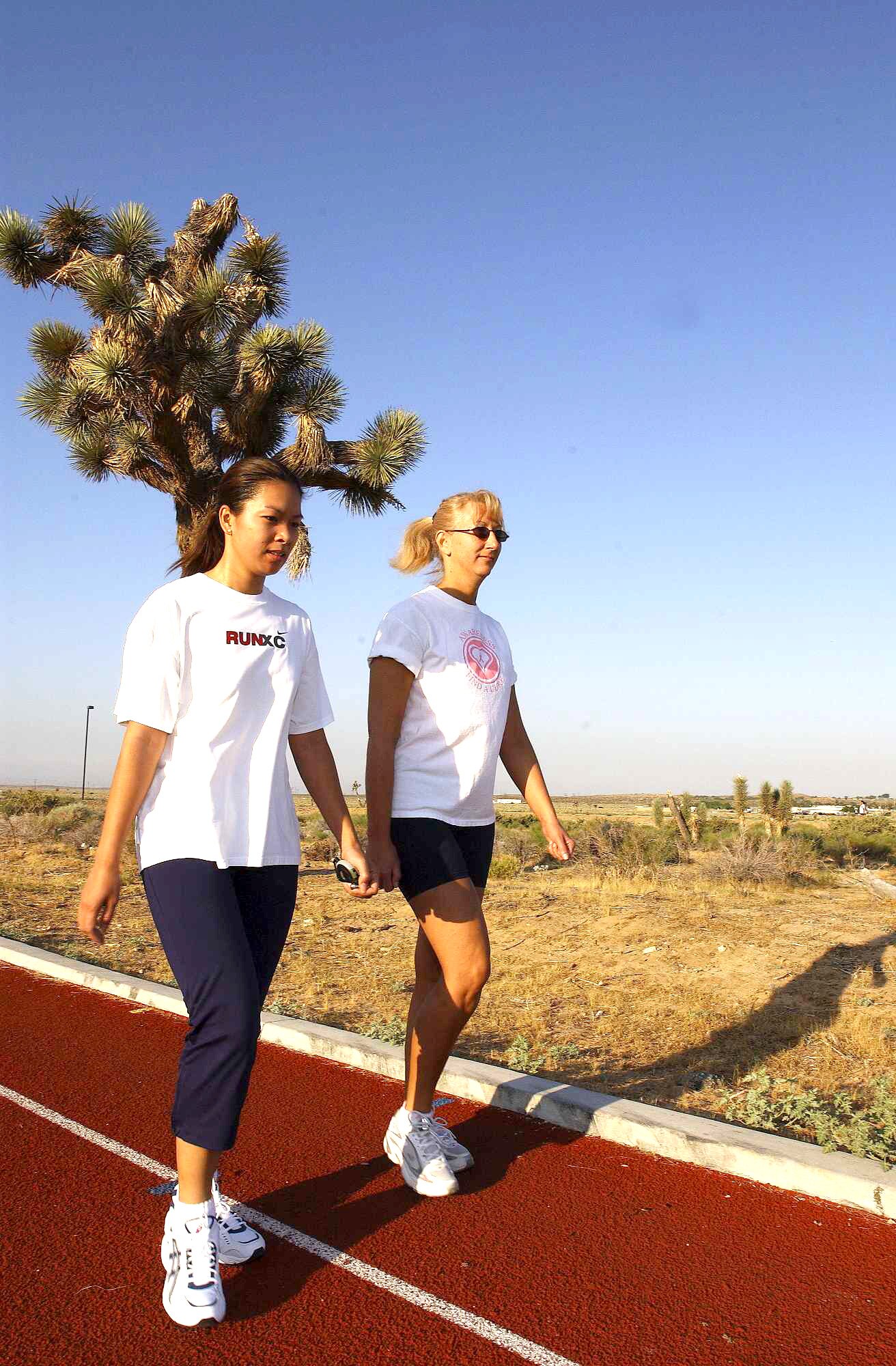 EDWARDS AIR FORCE BASE, Calif. -- Tech Sgt. Chonthicha Lane (left) and Michelle Chebahtah train before participating in a walk to support breast cancer research July 9 and 10.  Sergeant Lane is the noncommissioned officer in charge of the 412th Maintenance Operations Squadron here, and Ms. Chebahtah is the 412th Aircraft Maintenance Squadron training manager.  (U.S. Air Force photo by Chad Bellay)