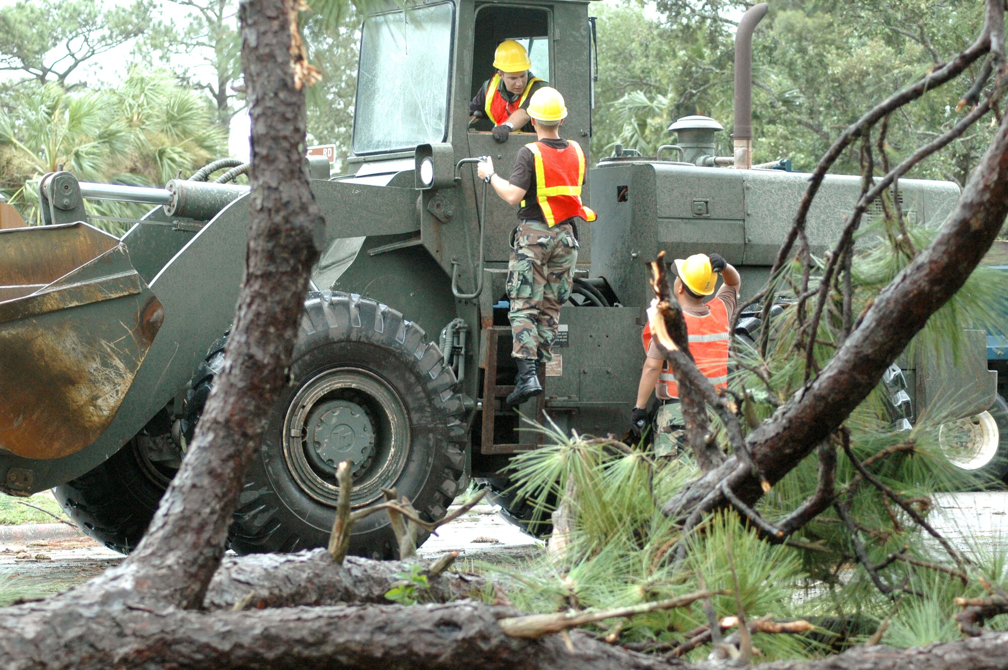 EGLIN AIR FORCE BASE, Fla. -- Senior Airman Shaun Cox (seated) lays out a plan with Airman 1st Class Brian Mikua and Senior Airman Michael Rambaran (far right) July 10 to clean up debris left here by Hurricane Dennis.  The Airmen are assigned to the 796th Civil Engineer Squadron.  (U.S. Air Force photo by Senior Airman Mike Meares)