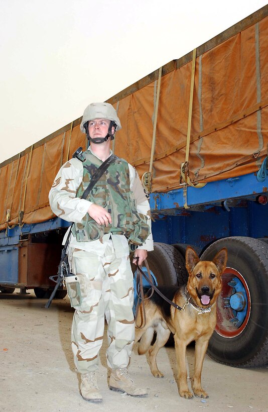 SOUTHERN IRAQ -- Staff Sgt. Gregory Long and his military working dog, Doran, walk down an endless row of civilian semitrailer trucks searching for explosives and contraband at a remote location.  They are assigned to the 407th Expeditionary Security Forces Squadron at Ali Base.  (U.S. Army photo by Master Sgt. Lek Mateo)