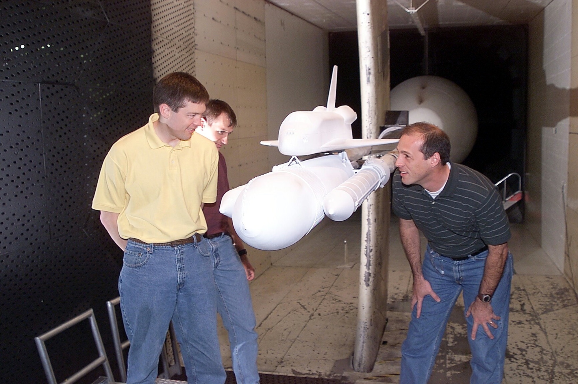 ARNOLD AIR FORCE BASE, Tenn. -- (From left) Jim Greathouse, Darby Vicker and Bob Ess examine a space shuttle model during a model change in the 16-foot transonic wind tunnel at the Arnold Engineering Development Center here.  Mr. Greathouse and Mr. Vicker are computational fluid dynamics analysts, and Mr. Ess is a program manager.  They are from NASA's Johnson Space Center in Houston.  (U.S. Air Force photo)