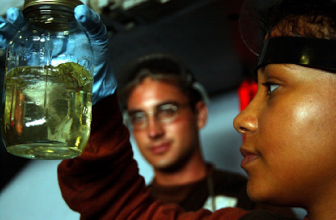 Navy Airman Malerie Love inspects a sample of JP5 jet fuel from an F/A-18 Hornet for contaminates in the hangar bay aboard the aircraft carrier USS Ronald Reagan (CVN 76) on July 11, 2005. The Nimitz class carrier Reagan is operating in the Pacific Ocean as it conducts Tailored Ships Training Availability. 