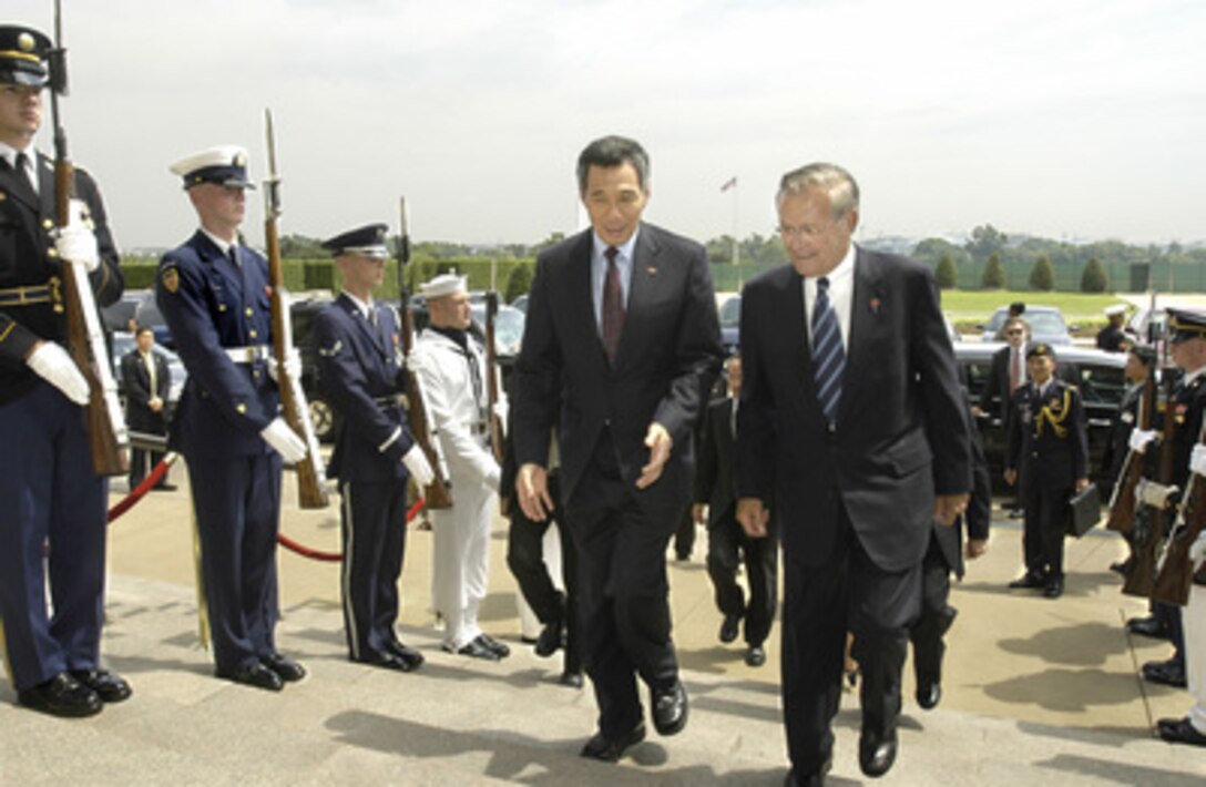 Secretary of Defense Donald H. Rumsfeld (right) escorts Singapore's Prime Minister Lee Hsien Loong (left) through an honor cordon and into the Pentagon on July 12, 2005. Rumsfeld and Lee will meet to discuss a broad range of security issues of mutual interest. 