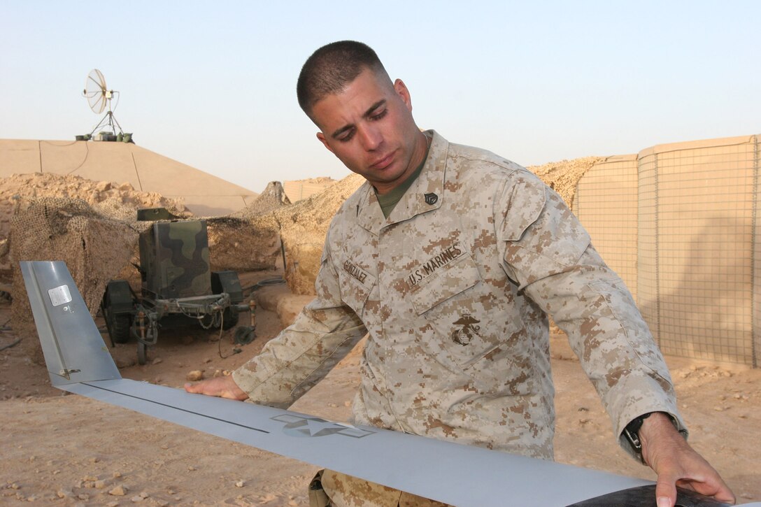 AL ASAD, Iraq - Staff Sgt. Jose Gonzalez, the staff noncommissioned officer-in-charge of the ScanEagle detachment with Marine Unmanned Aerial Vehicle Squadron 2 takes a wing off of a ScanEagle unmanned aerial vehicle after another successful reconnaissance mission here July 14. Gonzalez?s unit, VMU-2, is among the most deployed units in the Marine Corps serving in every phase of Operation Iraqi Freedom with plans to return next year.