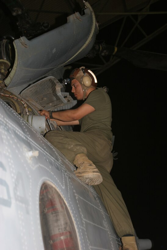 AL ASAD, Iraq - Lance Cpl. Raul Vasquez, a flightline mechanic with HMM-764 and Oxnard, Calif., native, works to repair a filter onboard a Moonlight CH-46 during scheduled routine maintenance. The flightline division is made up of engine mechanics, flightline mechanics and crew chiefs who work together to prepare their aircraft for combat operations.