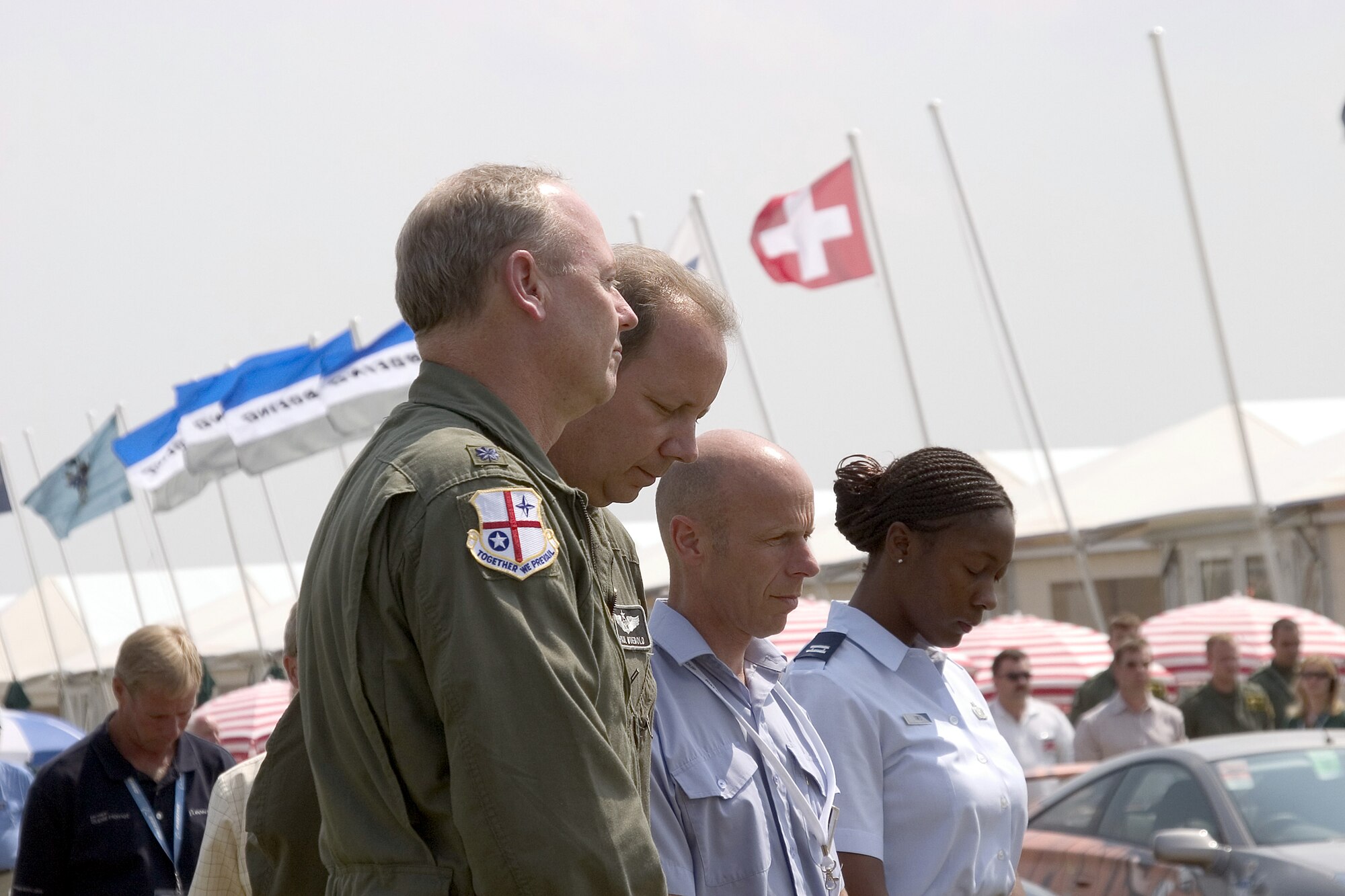 ROYAL AIR FORCE FAIRFORD, England -- (Left to right) Col. Paul Wuebold and Lt. Col. Tom Gill join Squadron Leader William Wain and Capt. Toni Tones, as they pay their respects during the countrywide two-minute moment of silence July 14.  The tribute was in remembrance of the victims of the terrorist attacks in London on July 7.  Colonel Wuebold is the commander of the 420th Air Base Group here, and Colonel Gill is the deputy commander.  Mr. Wain is the station commander here, and Captain Tones is assigned to the U.S. Air Forces in Europe public affairs office.  (U.S. Air Force photo by Terry Prucha)
