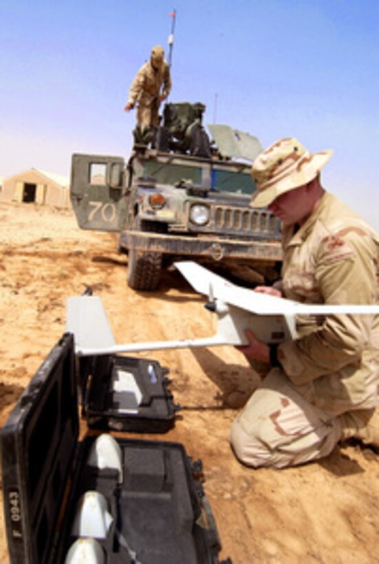 Army Cpl. Jerry Rogers assembles a RQ-11 Raven unmanned aerial vehicle in order to conduct aerial tactical reconnaissance of insurgents in Taji, Iraq, on June 21, 2005. The Raven has video cameras located in the nose cone and can relay live video back to the operator in real-time. Rogers is attached to the Scout Platoon, 1st Battalion, 13th Armor Regiment, 3rd Brigade, 1st Armored Division. 