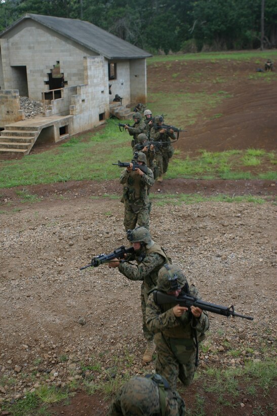 Marines with 1st Platoon, Alpha Company, 1st Battalion, 3rd Marine Regiment, rush toward their objective,  a house at the MOUT facility, Schofield Barracks, July 14. The Marines were conducting a building clearing exercise inside a three story building.