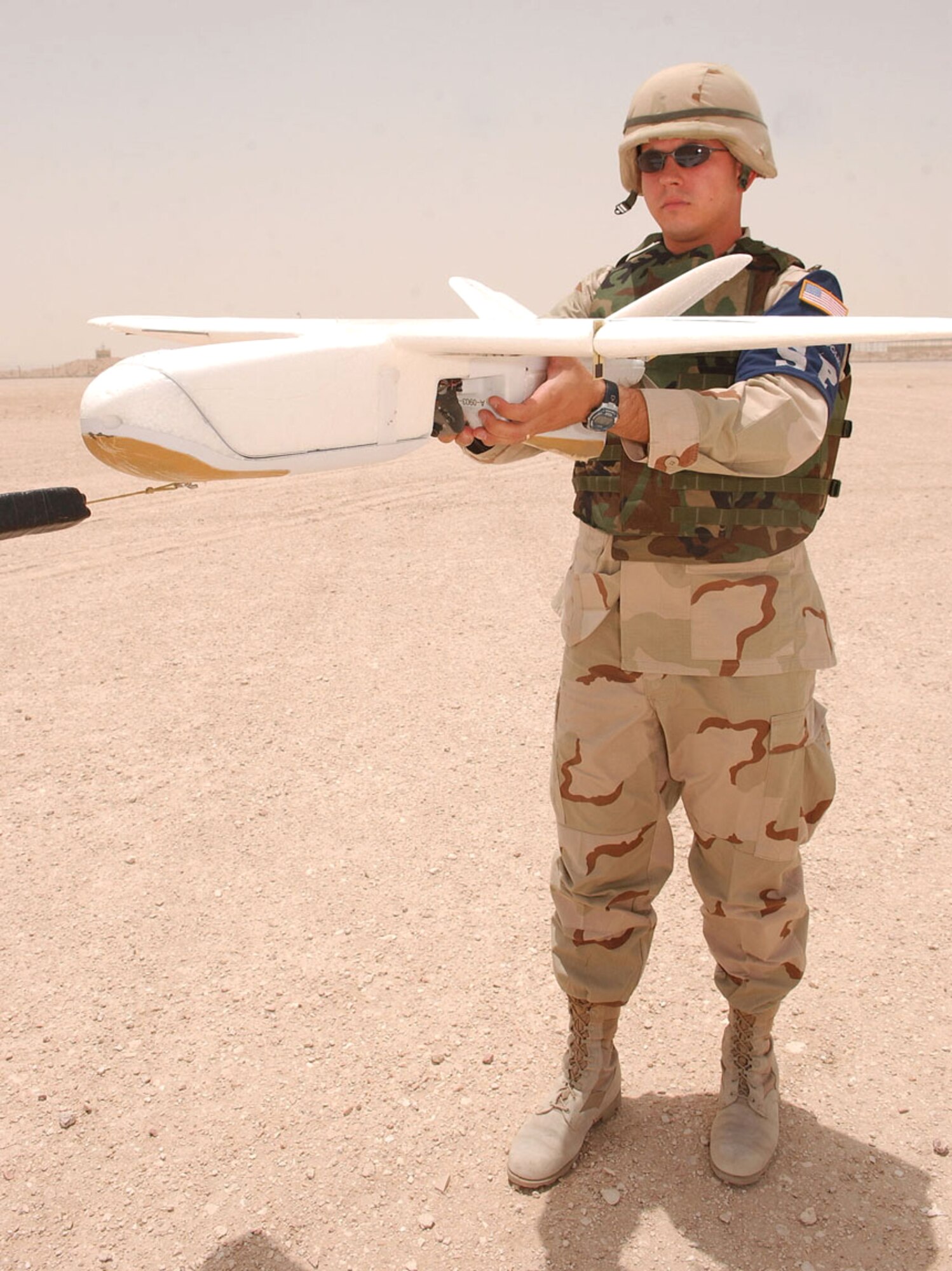 SOUTHWEST ASIA -- Staff Sgt. Dustin Heger prepares to launch a force protection airborne surveillance system.  The vehicle requires a bungee cord to reach a speed of 50 feet per second at which time the engine engages.  Sergeant Heger is assigned to the 379th Expeditionary Security Forces Squadron at a forward-deployed location and is from Elmendorf Air Force Base, Alaska.  (U.S. Air Force photo by Tech. Sgt. Randy Mallard)