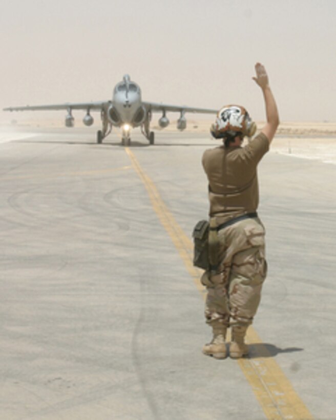 Navy Airman Broquel Schaefer signals the pilot of a Navy EA-6B Prowler as it taxis after a landing at Al Asad, Iraq, on July 8, 2005. The EA-6B Prowlers from Electronic Attack Squadron 138 usually operate aboard the aircraft carrier USS Carl Vinson (CVN 70) but are currently flying out of Al Asad in order to support operational commitments in Iraq. Schaefer is a plane captain in the squadron, which is deployed from Naval Air Station Whidbey Island, Wash. 