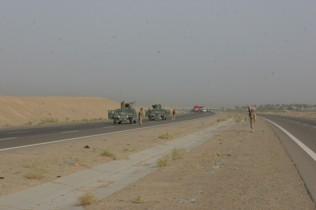 CAMP FALLUJAH, Iraq – Marines with Military Police Detachment, Combat Logistics Battalion 8, 2d Force Service Support Group (Forward), dismount their vehicles and provide area security while conducting security patrols here. The MPs conduct security patrols along certain major roadways in the Fallujah area to eliminate the insurgent threat and ensure safe passage for Coalition Forces. (Photo by Cpl. John E. Lawson Jr.)