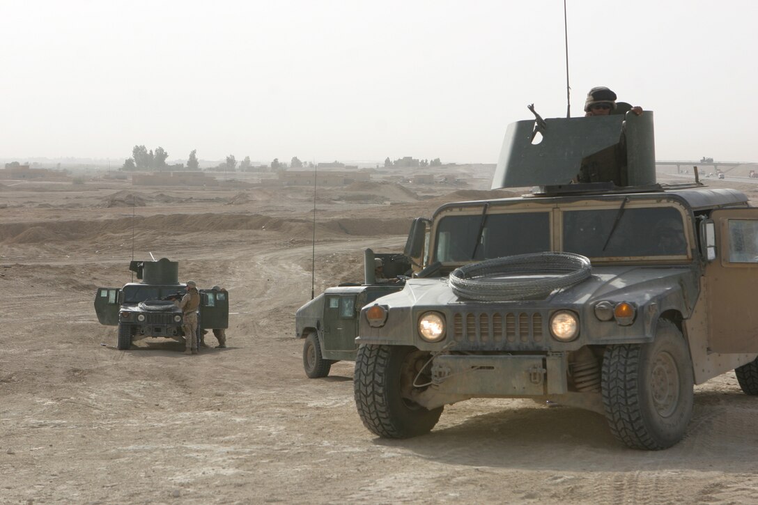 CAMP FALLUJAH, Iraq – Marines with Military Police Detachment, Combat Logistics Battalion 8, 2d Force Service Support Group (Forward), secure an area where insurgents have been known to emplace mines and Improvised Explosive Devices. The MPs, assisted by a combat engineer, swept and cleared the area before continuing their security patrols here. The MPs conduct the patrols along certain major roadways in the Fallujah area to eliminate the insurgent threat and ensure safe passage for Coalition Forces. (Photo by Cpl. John E. Lawson Jr.)