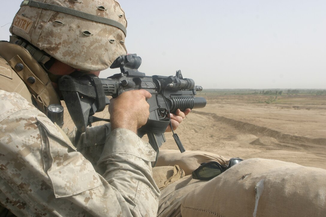 CAMP FALLUJAH, Iraq – Lance Cpl. Christopher R. Gentry, a military policeman with Military Police Detachment, Combat Logistics Battalion 8, 2d Force Service Support Group (Forward), provides security for his fellow Marines while conducting security patrols along certain major roadways in the Fallujah area. The MPs patrol the roadways looking for possible mines and Improvised Explosive Devices as they strive to eliminate any insurgent activity and secure safe passage for Coalition Forces in the area. (Photo by Cpl. John E. Lawson Jr.)