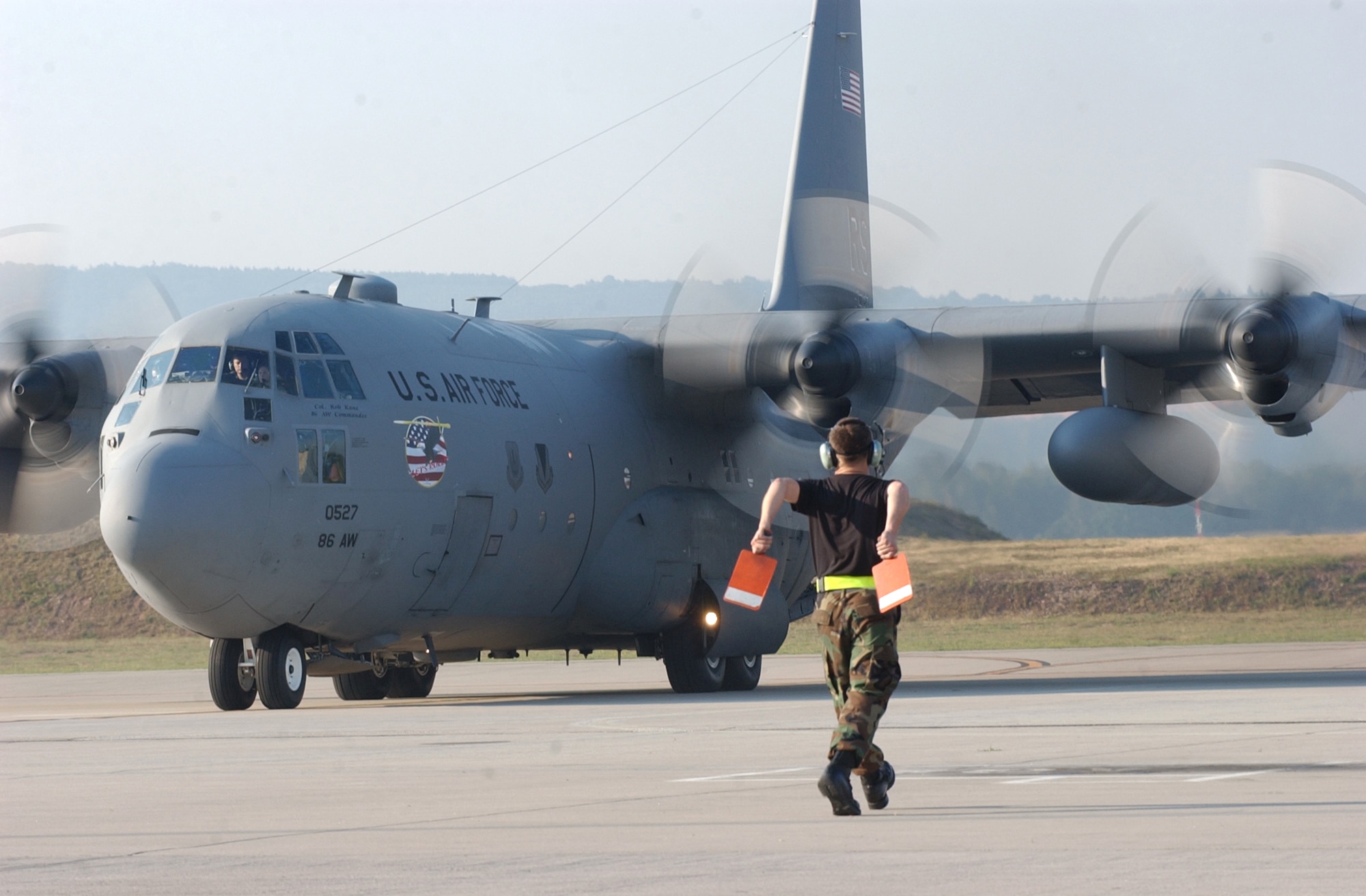 RAMSTEIN AIR BASE, Germany -- A C-130 Hercules from the 86th Airlift Wing is marshaled onto the taxiway here July 16 on its way to Kigali, Rwanda, for a monthlong airlift mission to the Darfur region of Sudan.  Three C-130 aircraft and about 40 Airmen here will support NATO's response to support the African Union's expanded peacekeeping mission in Darfur with logistics and training.  (U.S. Air Force photo by Master Sgt. David D. Underwood Jr.)