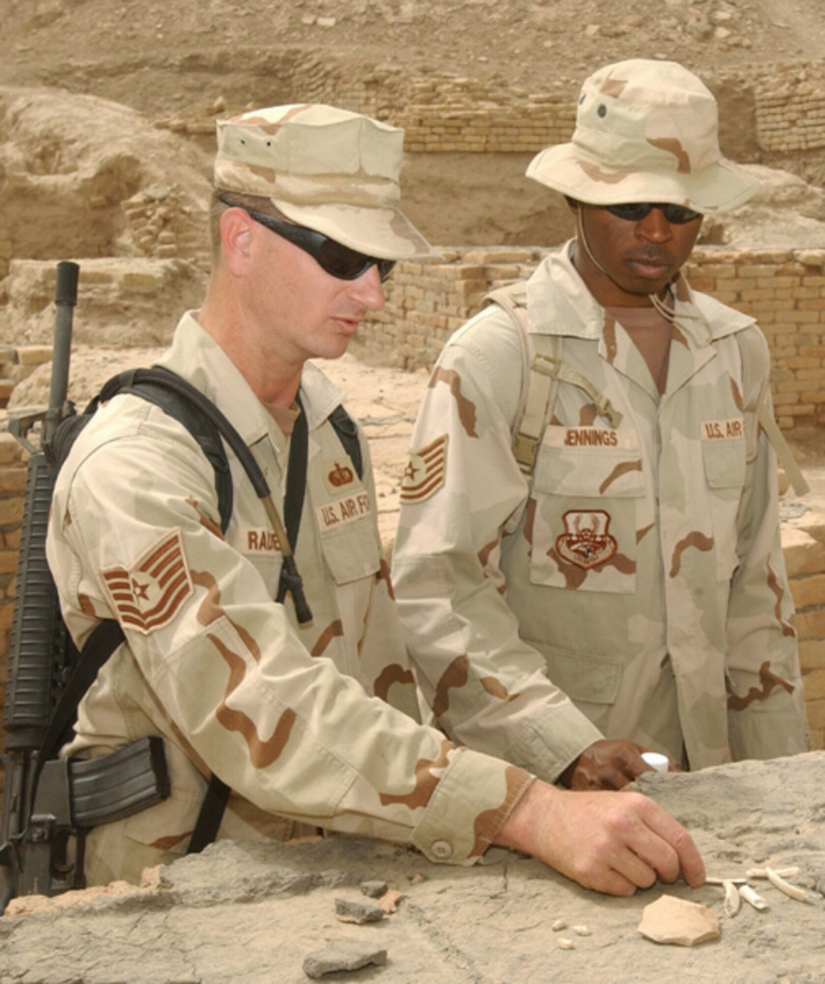 ALI BASE, Iraq -- Tech. Sgt. Mike Radke (left) shows Tech. Sgt. Barrington Jennings how to tell the difference in the character signatures among coral, sea shells, pottery and human bones.  Sergeant Radke is assigned to the 407th Expeditionary Services Squadron and is one of two Airmen within the squadron who gives tours of a 4,000-year-old monument.  Sergeant Jennings is assigned to the 407th Air Expeditionary Group.  They are deployed from McConnell Air Force Base, Kan.  (U.S. Air Force photo by Airman 1st Class Jamie Shultz)