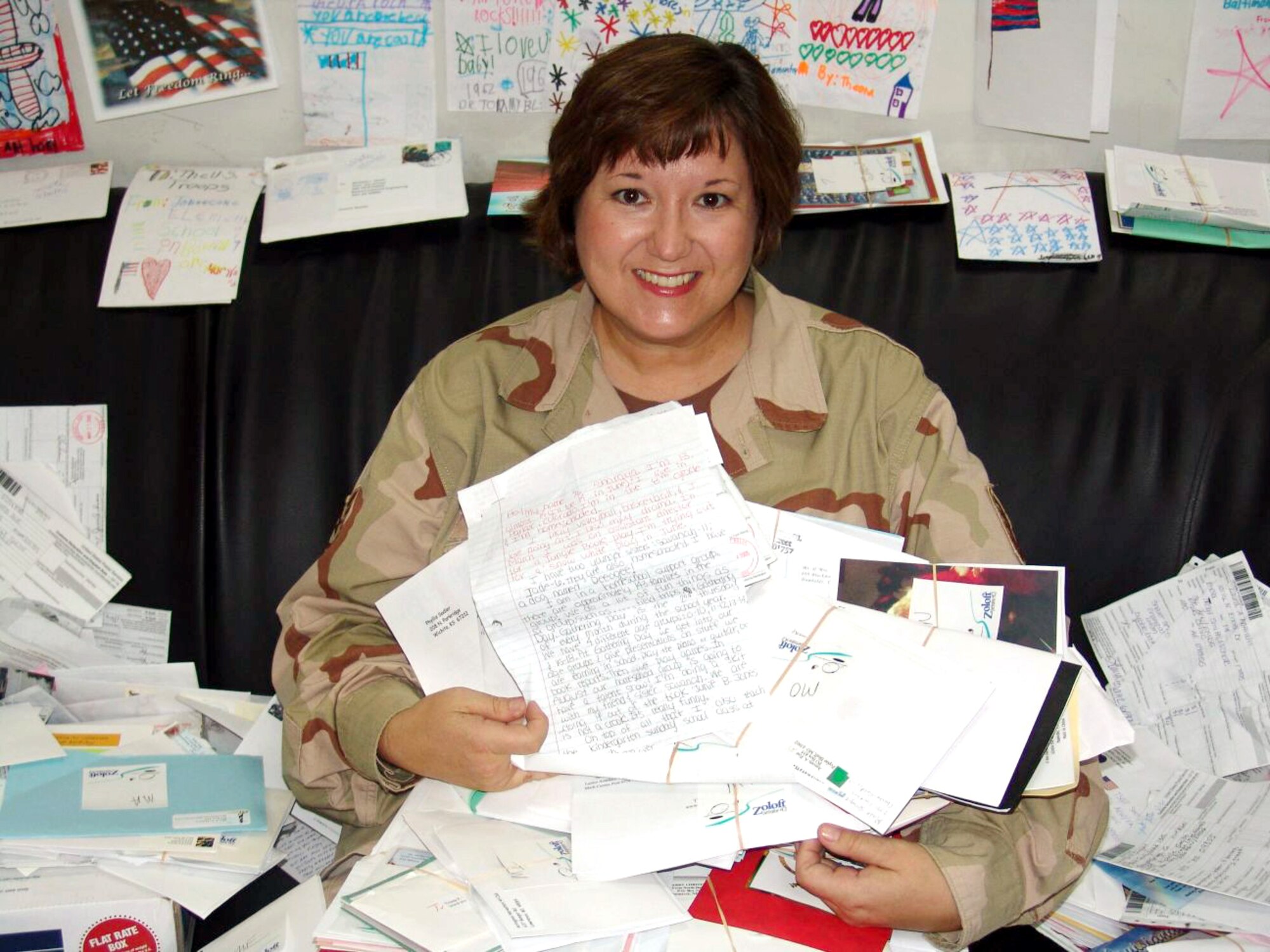 SOUTHWEST ASIA -- Tech. Sgt. Michelle Smith displays her many letters, cards and pictures mailed to her by various supporters.  She is the noncommissioned officer in charge of the 386the Expeditionary Medical Group's bioenvironmental engineering office at a forward-deployed location.  (U.S. Air Force photo by Staff Sgt. Carlos Diaz)

