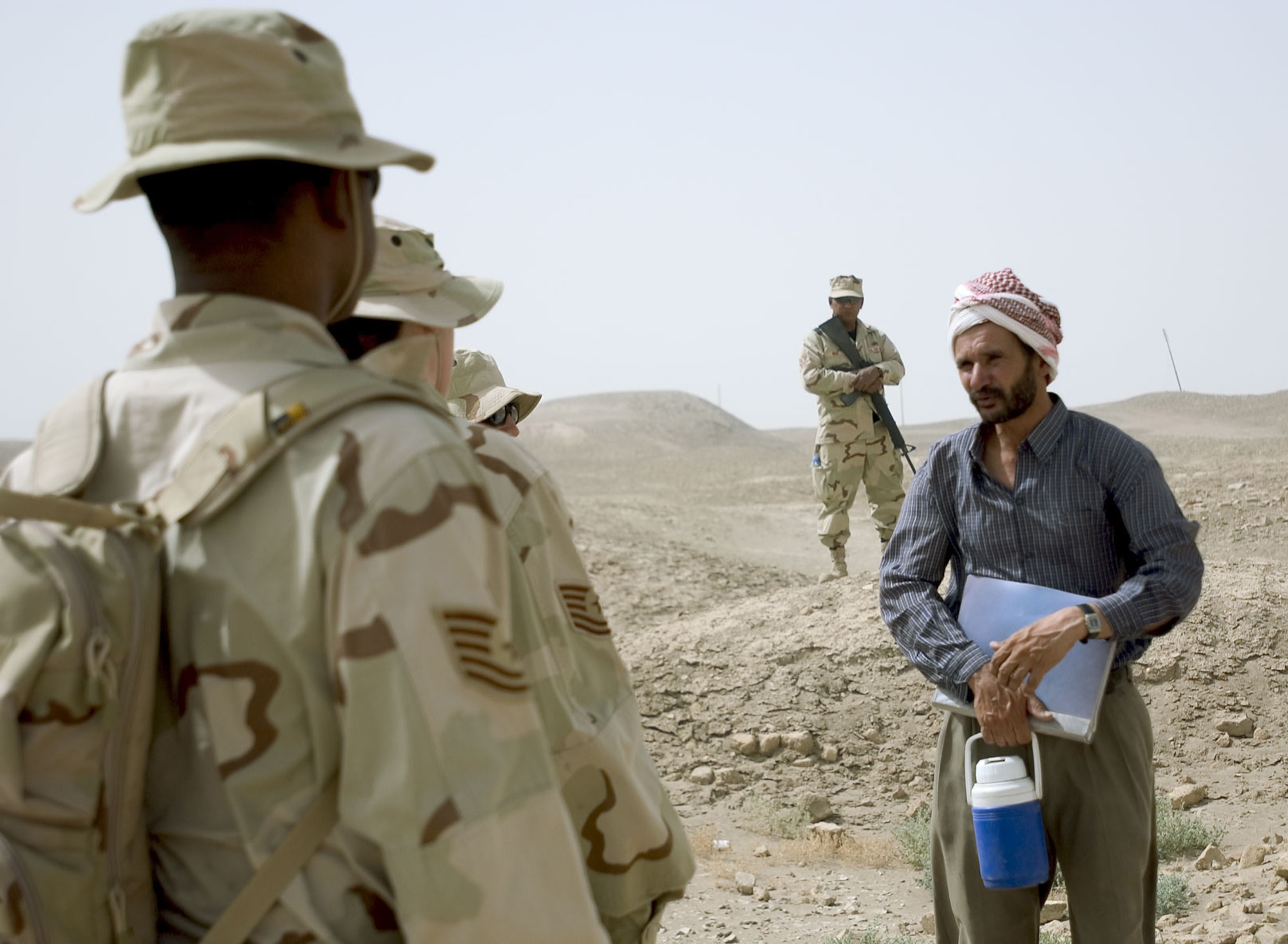 ALI BASE, Iraq -- Staff Sgt. Nat Ruiz (background) provides security for Airmen on a recent visit to the ziggurat of Ur.  Dhaif, the site's caretaker and tour guide, talks about the history of the 4,000-year-old monument.  Sergeant Ruiz is assigned to the 407th Expeditionary Services Squadron and is deployed from Laughlin Air Force Base, Texas.  (U.S. Air Force photo by Master Sgt. Maurice Hessel)