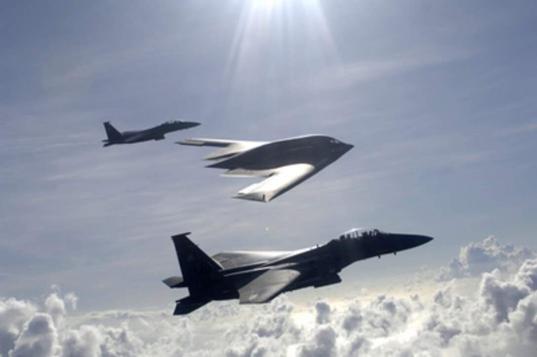 Two U.S. Air Force F-15E Strike Eagles and a B-2 Spirit bomber fly in formation over the Pacific Ocean on July 7, 2005. The Strike Eagles of the 391st Expeditionary Force Squadron and the stealth bomber from the 393rd Expeditionary Bomb Squadron at Whiteman Air Force Base, Mo., are deployed to Andersen Air Force Base, Guam, to maintain a continuous presence in the Asia-Pacific region. 