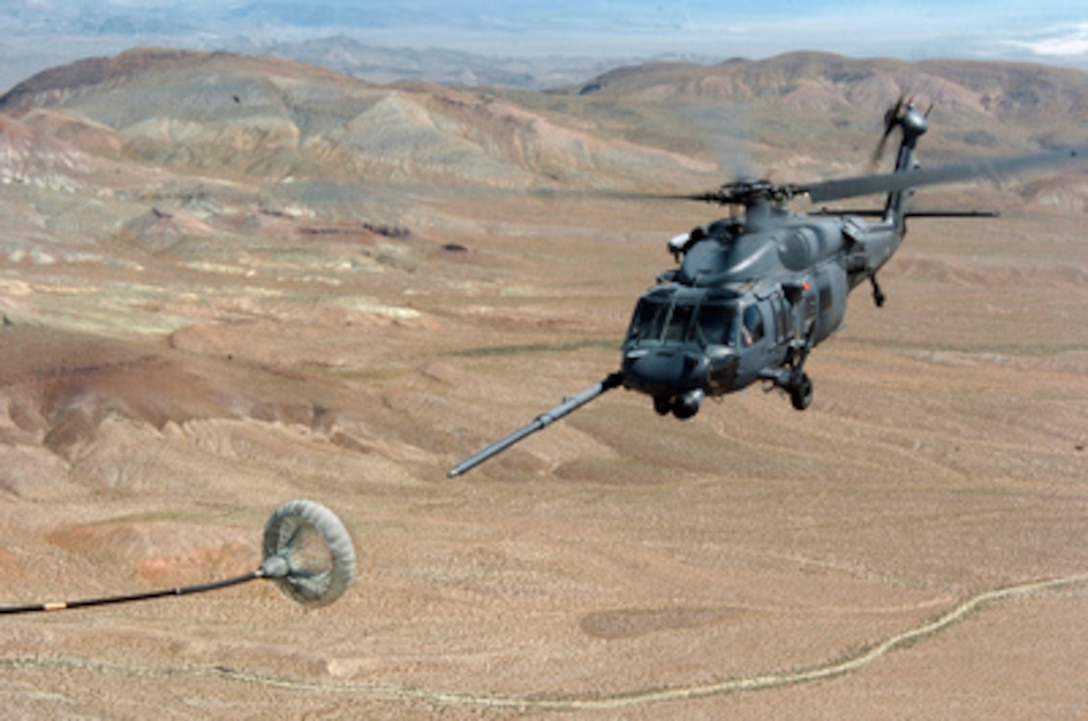 A U.S. Air Force HH-60H Pave Hawk helicopter approaches a refueling basket as it prepares to refuel in flight from an HC -130 Hercules during training Exercise Desert Rescue over Fallon, Nev., on July 14, 2005. Desert Rescue is a multi-service, multi-national training exercise to prepare combat search and rescue teams to extract downed personnel in a variety of environments and situations. 