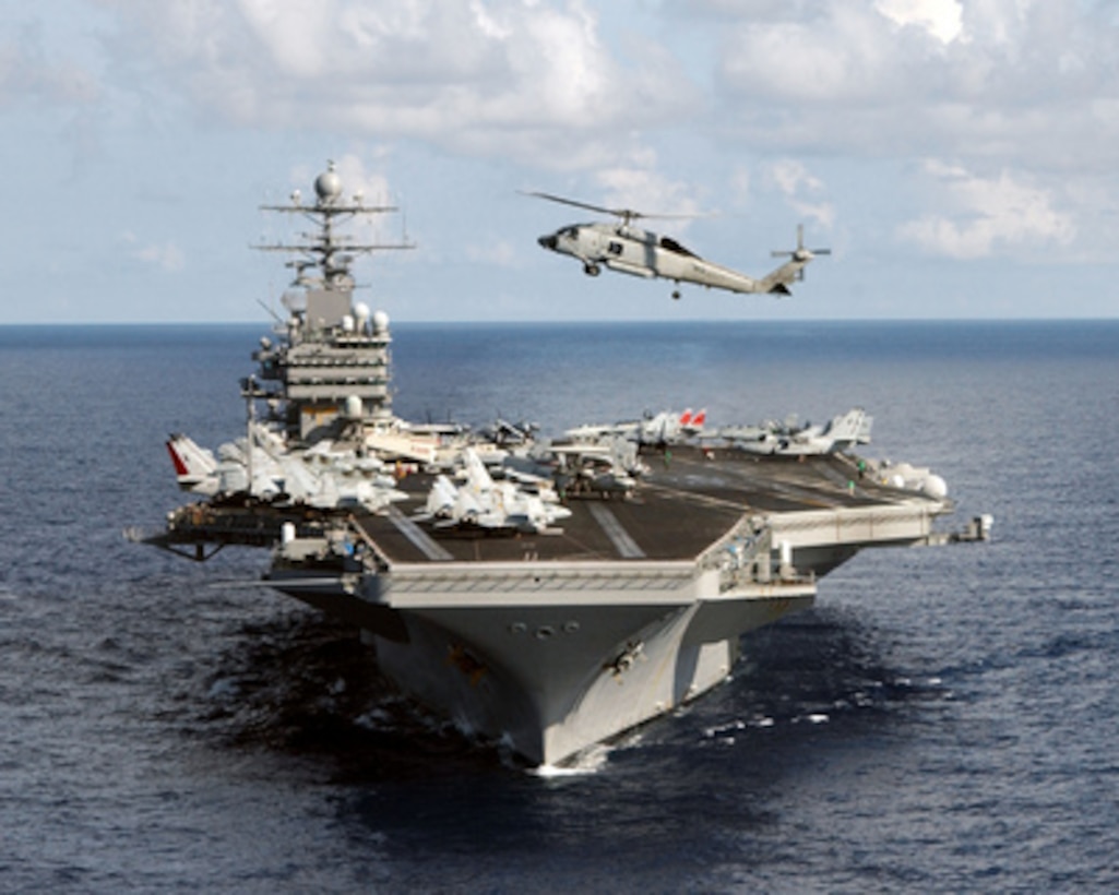 A Navy SH-60 Seahawk helicopter flies over the bow of the aircraft carrier USS Theodore Roosevelt (CVN 71) as the ship conducts a close quarters exercise in the Atlantic Ocean on July 15, 2005. The Theodore Roosevelt Carrier Strike Group is taking part in a Joint Task Force Exercise in the Atlantic. 